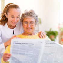 woman behind elder lady reading newspaper