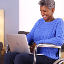 elder lady smiling in front of laptop